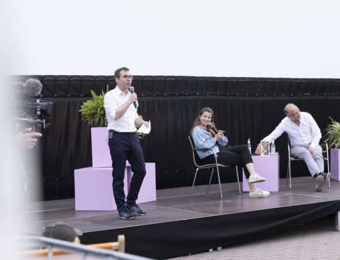Simon Hauser moderiert ein Podiumsgespräch auf einer Open-Air-Bühne