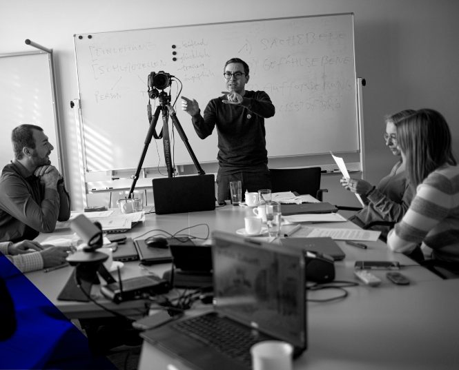 Schwarz-Weiß-Aufnahme: Simon Hauser im Gespräch bei einem Workshop
